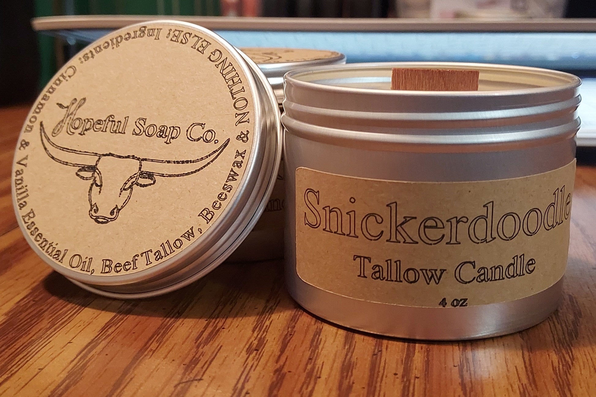 Tallow candle with 'Snickerdoodle' flavor and 'Hopeful Soap Co.' branding on a wooden surface.