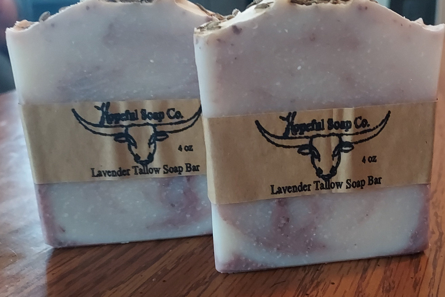 Two lavender soap bars from Hopeful Soap Co on a wooden surface.