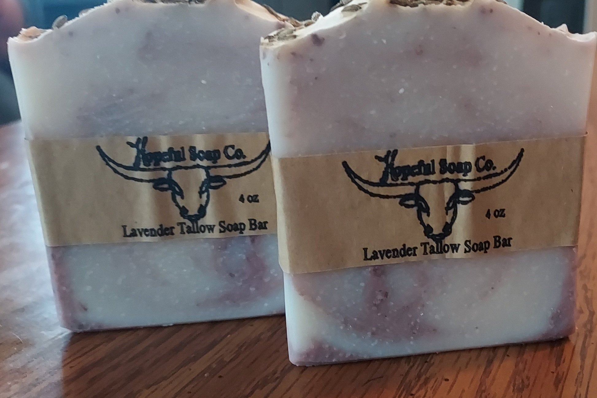 Two lavender soap bars from Hopeful Soap Co on a wooden surface.